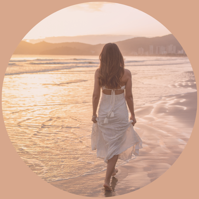 Femme marchant au bord de l’eau au coucher du soleil, symbole d’accompagnement pour retrouver calme et clarté près de Toulouse et Pamiers.