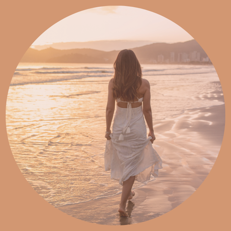 Femme marchant au bord de l’eau au coucher du soleil, symbole d’accompagnement pour retrouver calme et clarté près de Toulouse et Pamiers.