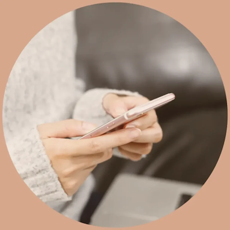 Femme utilisant son téléphone pour consulter les informations pratiques et contacter une hypnothérapeute dans le Lauragais, près de Toulouse